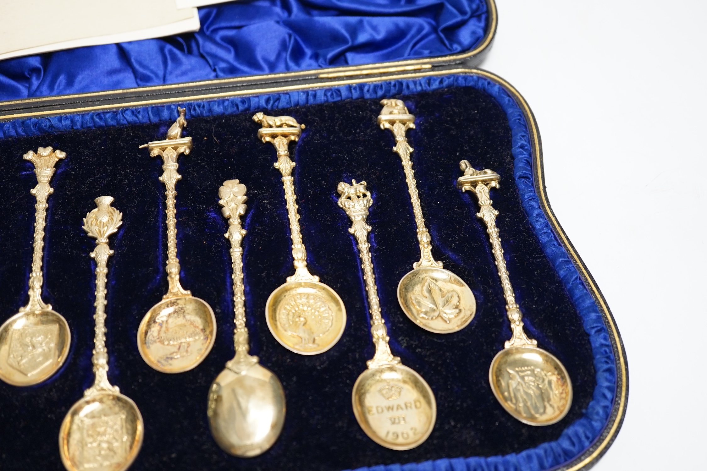 A set of twelve Edwardian silver gilt 'Greater Britain' souvenir spoons, Edward Barnard & Sons, London, 1902, 12.1cm, 8.4oz.